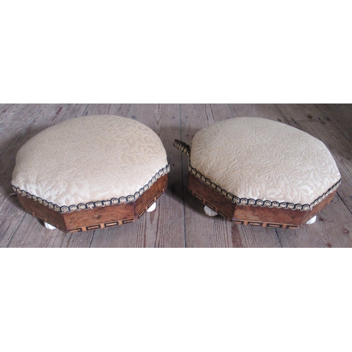 58 - A pair of Victorian walnut and upholstered octagonal foot stools, raised on porcelain feet