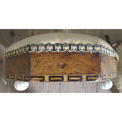 58 - A pair of Victorian walnut and upholstered octagonal foot stools, raised on porcelain feet