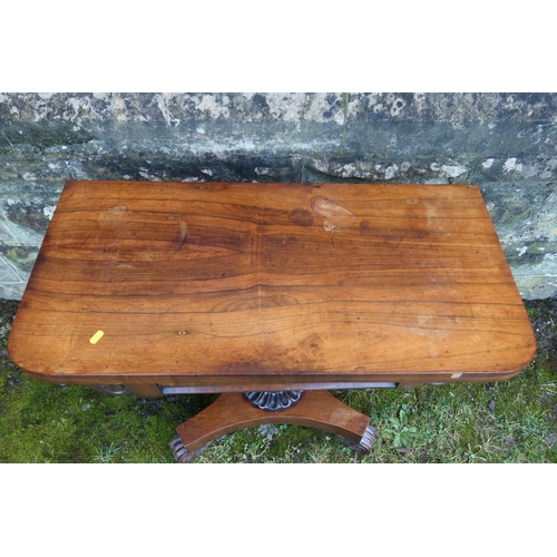 12 - A 19th century rosewood fold over games table, raised on an octagonal column terminating in a platfo... 