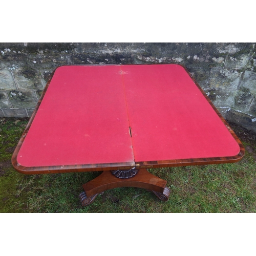 12 - A 19th century rosewood fold over games table, raised on an octagonal column terminating in a platfo... 