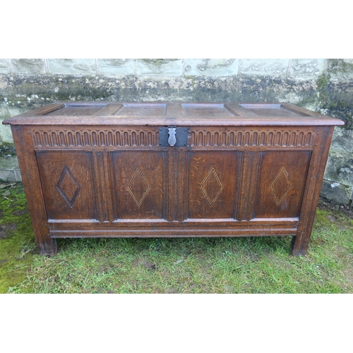 17 - An oak coffer, with four lozenge panels below a four panel raising lid, width 58ins