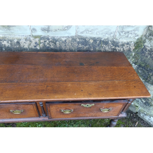 20 - An early 19th century oak three drawer dresser base, raised on turned front legs, width 78ins