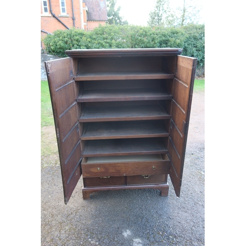 25 - A Georgian mahogany press cupboard, having two cross banded doors, revealing five slide out trays an... 