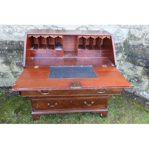 26 - A late Georgian mahogany fall flap bureau, with doors and pigeon holes, with four drawers below, wid... 