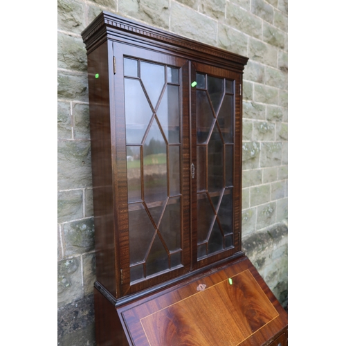 29 - A reproduction mahogany bureau bookcase, with fitted glass doors and four drawers, width 29ins