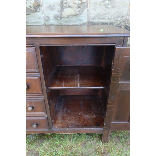 30 - An Ecrol style oak sideboard, fitted with an arrangement of drawers, flanked by two cupboards, 58ins... 