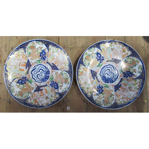 430 - A pair of large Japanese Imari chargers, decorated with sectional scenes of gardens and figures to a... 