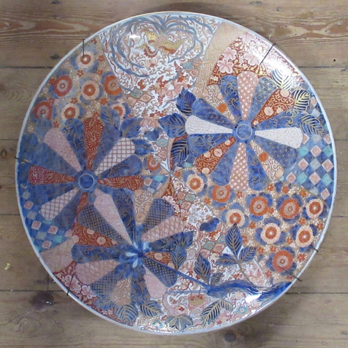 432 - A large 19th century Japanese Imari charger, decorated with fans and panels of flowers, in the typic... 