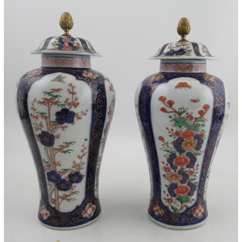 433 - A pair of 20th century Chinese covered vases, decorated with panels of flowers, red seal mark to the... 