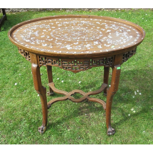 11 - An Eastern oval wooden and inlaid occasional table, inlaid with mother of pearl, having a pierced fr... 