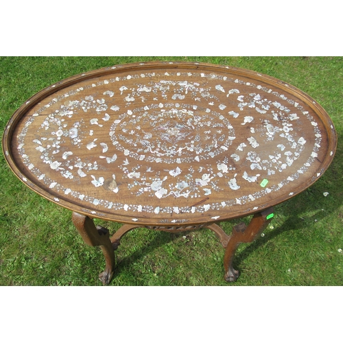 11 - An Eastern oval wooden and inlaid occasional table, inlaid with mother of pearl, having a pierced fr... 