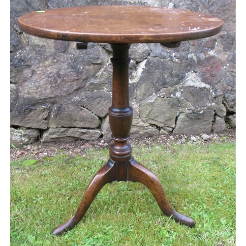 52 - A 19th century oak tilt top tripod table, raised on a turned column, with three outswept supports, d... 