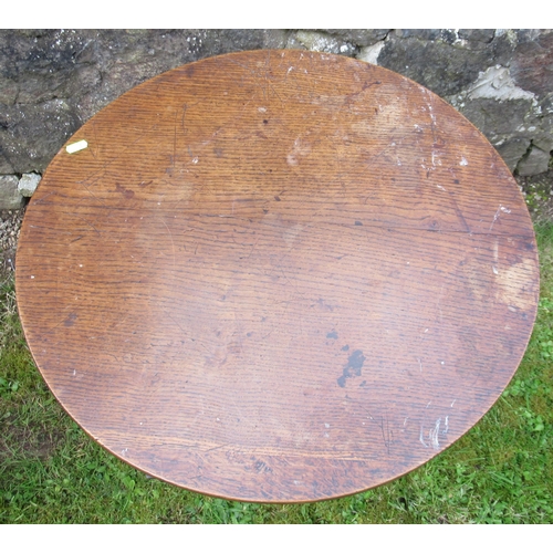 52 - A 19th century oak tilt top tripod table, raised on a turned column, with three outswept supports, d... 