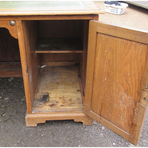 78 - An oak desk, with tooled leather writing surface, the ne pedestal fitted with four drawers, the othe... 