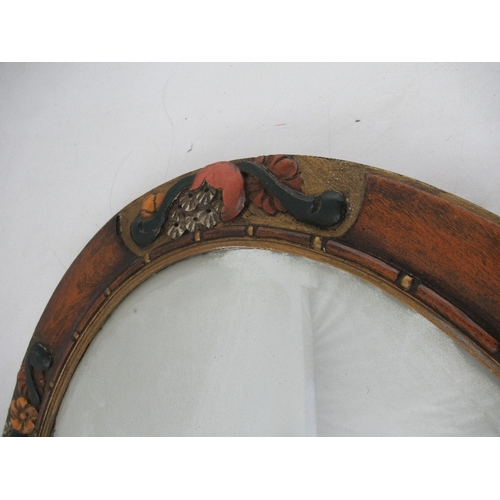 12 - An oval mirror, having a painted and carved frame, with beveled plate, width 24ins