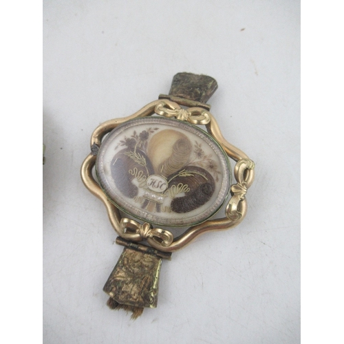 162 - Two 19th century rolled gold memento mori lockets mounted with locks of hair, seed pearls and wire w... 