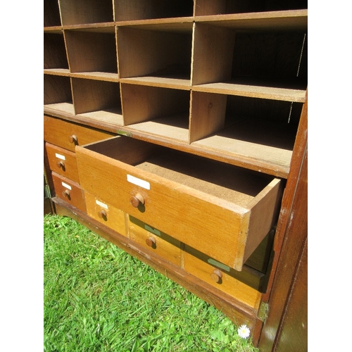 17 - An Arts and Crafts cabinet, with carved doors opening to reveal drawers and pigeon holes,