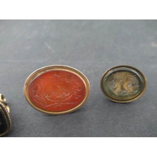 211 - Six Georgian and later gilt metal desk seals, all set with coloured hard stones, four engraved with ... 