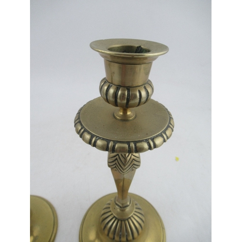 213 - A pair of heavy brass candle sticks with facetted stem, drip tray and circular base, height 10ins