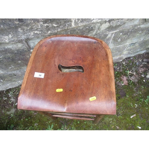 38 - A mahogany bar stool with shaped seat, raised on turned legs united by stretchers