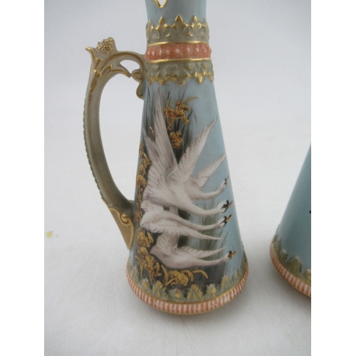 421 - A pair of left and Right Royal Worcester jugs each decorated with four swans on a powder blue ground... 