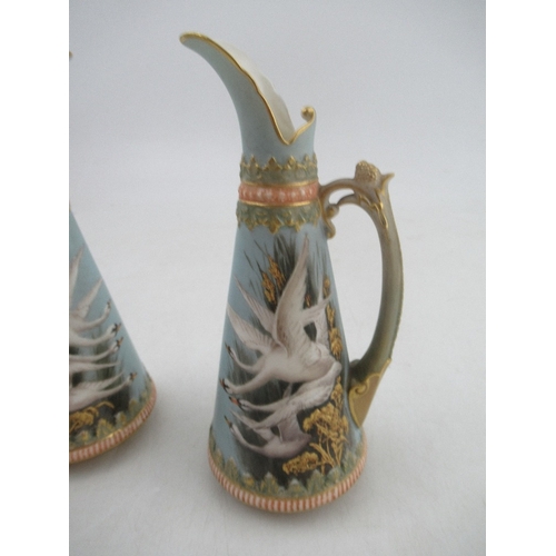 421 - A pair of left and Right Royal Worcester jugs each decorated with four swans on a powder blue ground... 