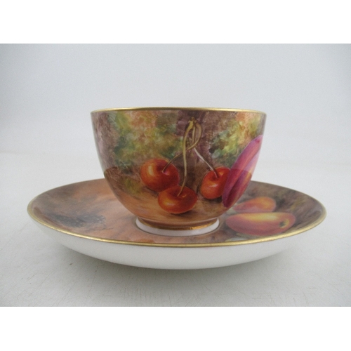 464 - A Royal Worcester cup and saucer, the exterior of the cup and the saucer decorated with fruit to a m... 