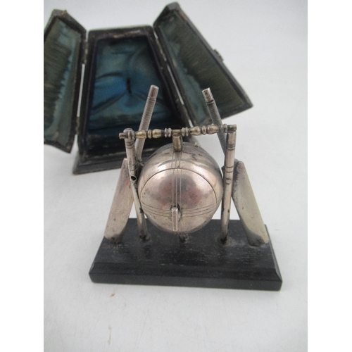 225 - A novelty silver plated desk clock, formed as a cricket ball, stumps, bails and bats, on plinth base... 