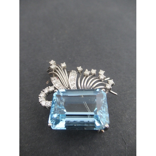 313 - A white gold aquamarine and diamond asymmetric brooch, claw set emerald cut aquamarine, with fan spr... 