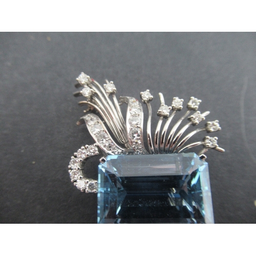 313 - A white gold aquamarine and diamond asymmetric brooch, claw set emerald cut aquamarine, with fan spr... 