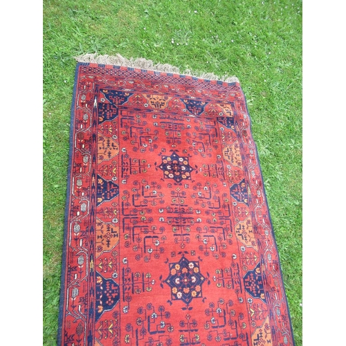 87 - An Eastern design rug/runner, decorated with geometric design to a red ground, 110ins x 40ins