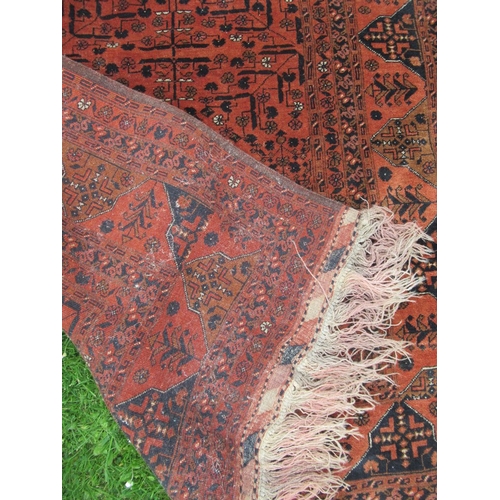 90 - An Eastern rug, with geometric decoration to a red ground, 75ins x 52ins