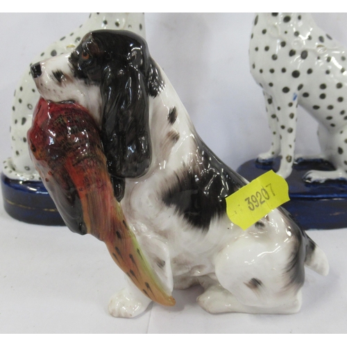 132 - A Royal Doulton model, of a seated spaniel with a pheasant, together with a pair of Staffordshire mo... 