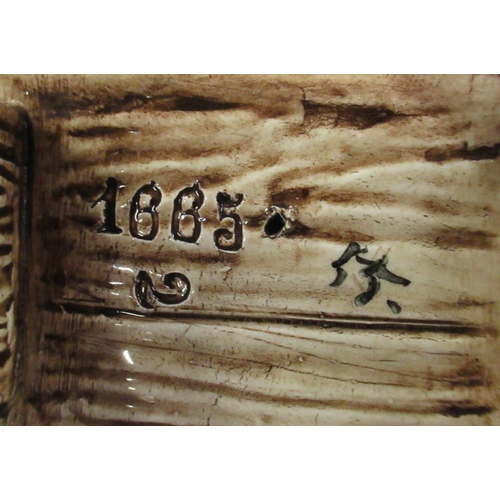 133 - A pair of Continental pottery models, of a boy and a girl seated on benches, height 6ins