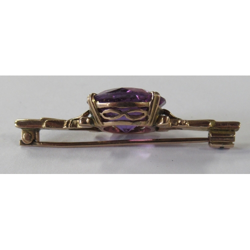 210 - A gold bar brooch, set with a synthetic colour changing sapphire
