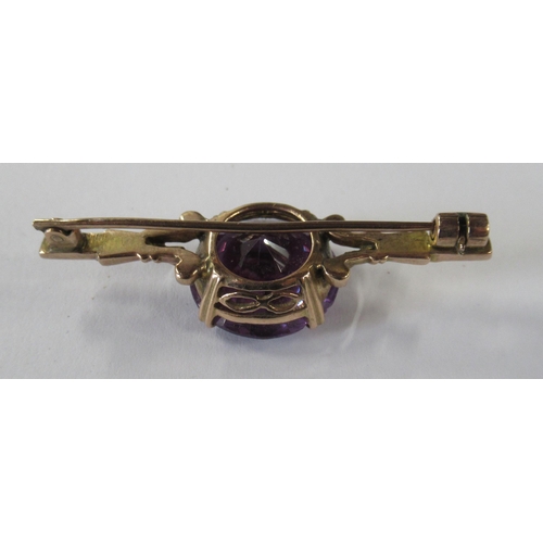 210 - A gold bar brooch, set with a synthetic colour changing sapphire