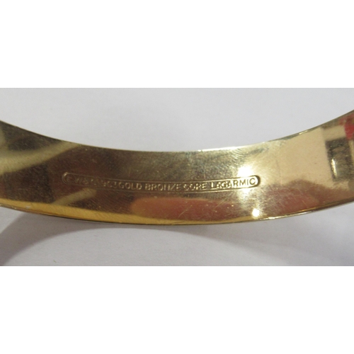 223 - A rolled gold hinged bracelet, with engraved decoration