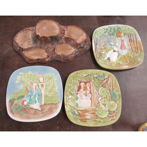 255 - A Beswick stand, for figures, together with three Beswick Beatrice Potter scene plates