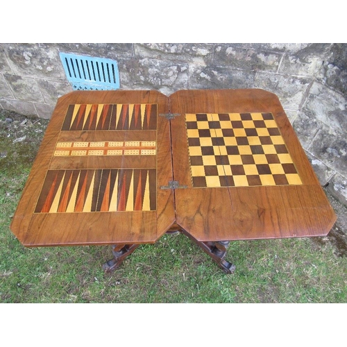 41 - A Victorian walnut games table, with swivel games top, over pull out drawer, raised on turned legs, ... 