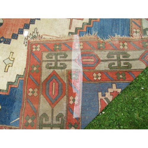 66 - A large carpet with a central blue, salmon pink and beige ground decorated with motifs with a simila... 