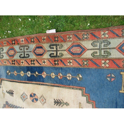 66 - A large carpet with a central blue, salmon pink and beige ground decorated with motifs with a simila... 
