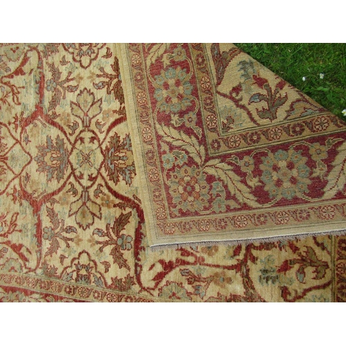 67 - An Eastern design carpet with a light brown central field with foliage and a similar boarder on a re... 