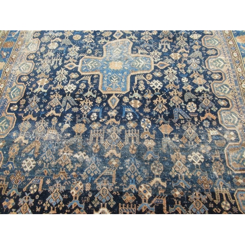 68 - An Eastern design carpet with a central blue field having a central foliage cross  76in x 58ins