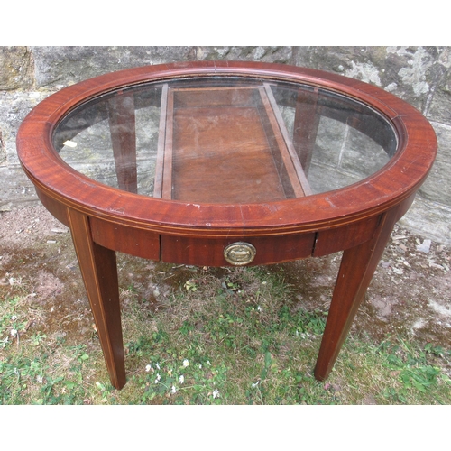 85 - An oval glass top coffee table, with a drawer, maximum diameter 27.5ins