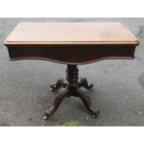 88 - A Victorian fold over tea table, raised on carved legs