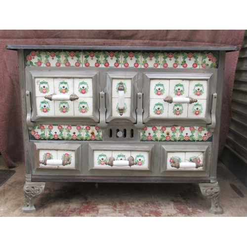 94 - A French cast iron stove, decorated with tiles, with cooking plates to the top, oven to the front an... 