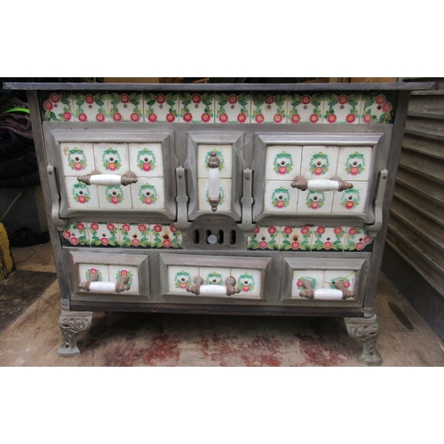 94 - A French cast iron stove, decorated with tiles, with cooking plates to the top, oven to the front an... 