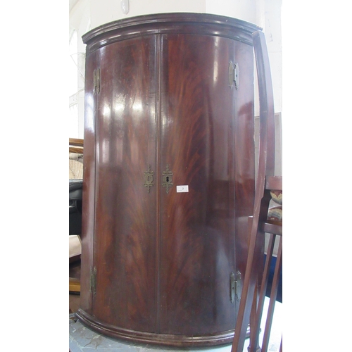 3 - An Antique barrel front mahogany corner cupboard, fitted with shelves and a drawer