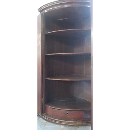 3 - An Antique barrel front mahogany corner cupboard, fitted with shelves and a drawer