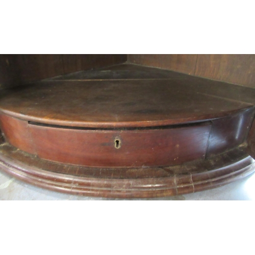 3 - An Antique barrel front mahogany corner cupboard, fitted with shelves and a drawer